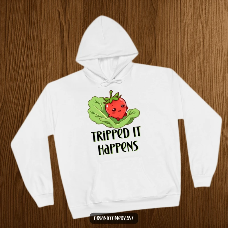 Funny hoodie featuring a bashful strawberry character tripping over a giant lettuce leaf, perfect warm and humorous apparel.